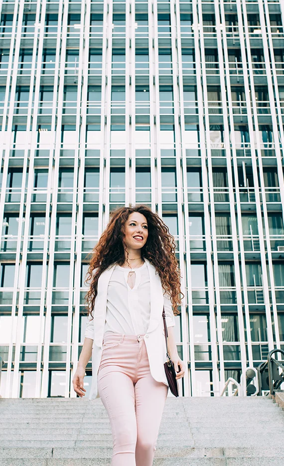 Image of business woman walking out of office feeling empowered