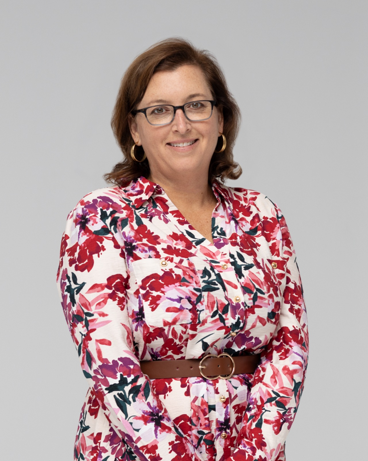 Amy Ross, Certified Hypnotherapist, smiling in a floral blouse
